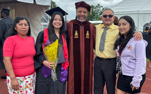 Medrano Jimenez with her family and former Instructional Dean Eric Benjamin (center), at MC Commencement ceremony, May 2024