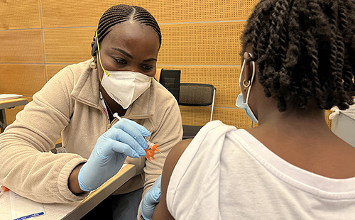 Nurse giving a young patient the COVID-19 vaccine