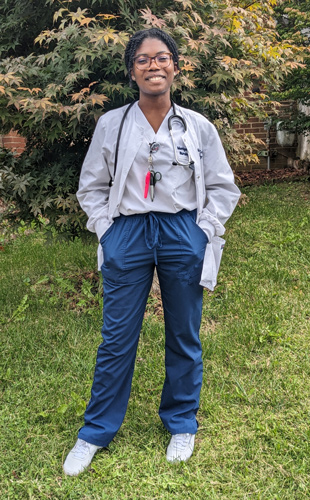 Beslin Aryeh standing outside in her nurses scrubs.