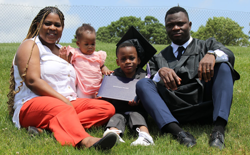 Sourou family sitting in the grass after commencement