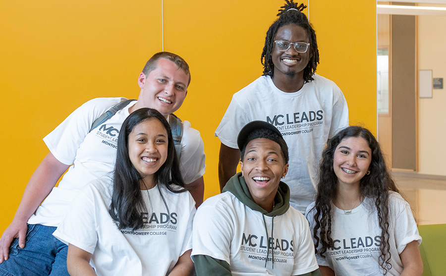 Five smiling students in MC Leads t-shirts