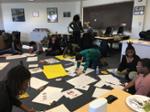 Students making posters on the floor