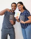 Two students showing off two books
